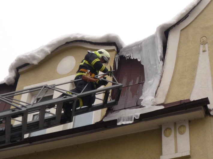 Ilustrační foto hasiče odstraňujícího rampouchy ze střechy